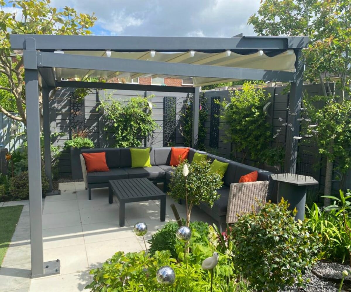 A pergola over a table and chairs in a garden