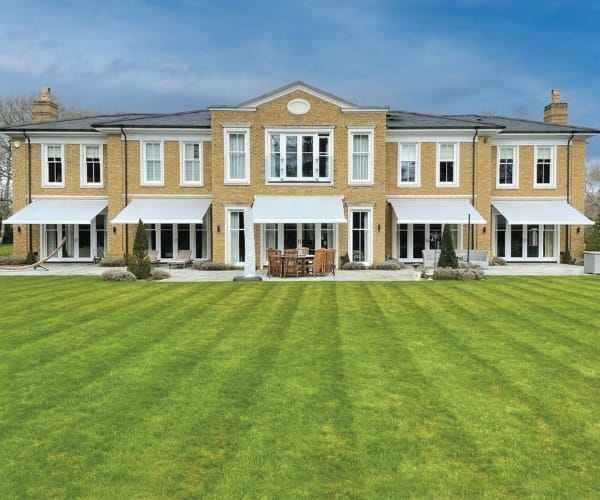 An awning on the outside of a large house as fitted by Great British Awning and Blind Company TM