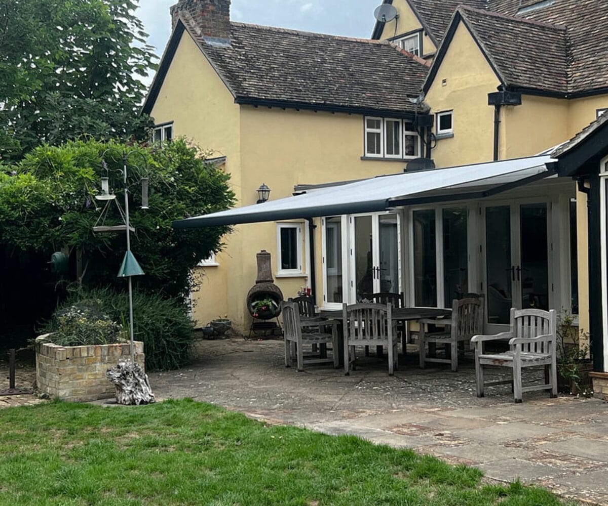 An awning on the outside of a stunning house as fitted by Great British Awning and Blind Company TM