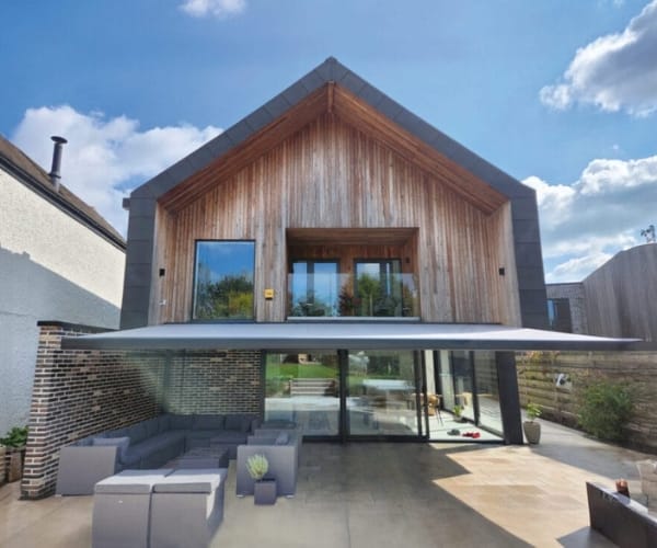 An outdoor furniture set under a Great British Awnings awning.