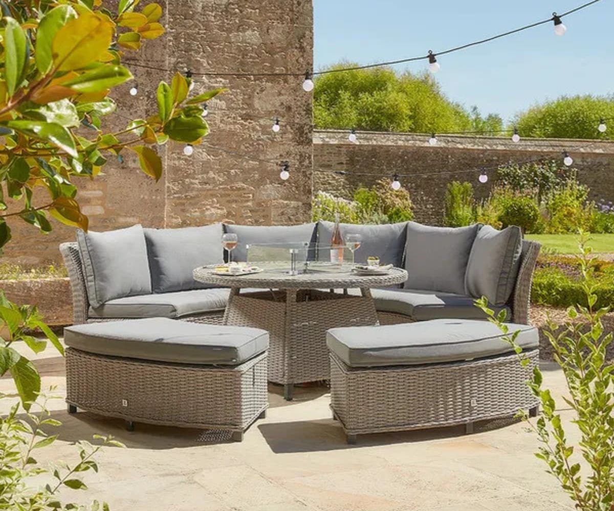 A table and chairs garden furniture set, grey, in a sunlit garden