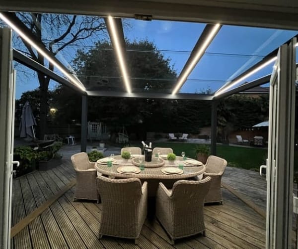 A glass veranda as installed by great british awnings in a winter evening