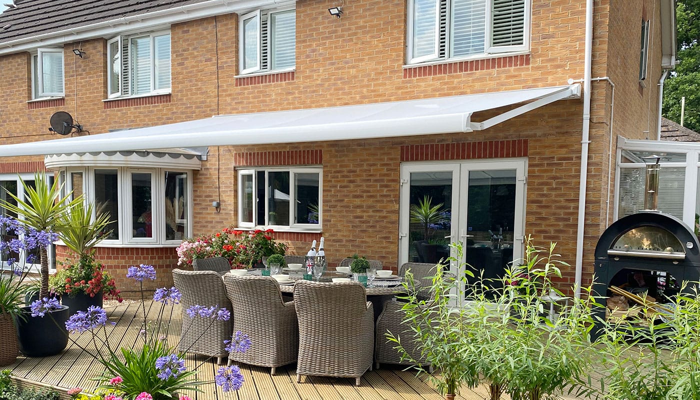 A Great British retractable electric awning professionally installed in a beautiful garden