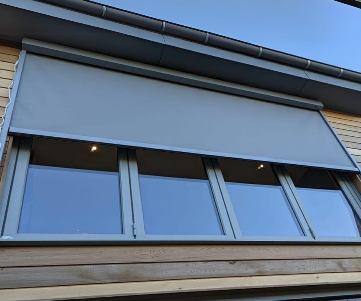 External window fitted with a sleek automated blind from The Great British Awning and Blinds Company, installed above a set of large glass doors