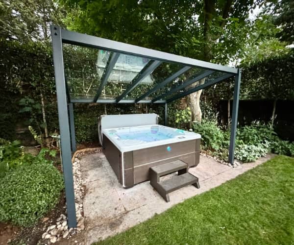 Glass veranda installed over hot tub in a garden