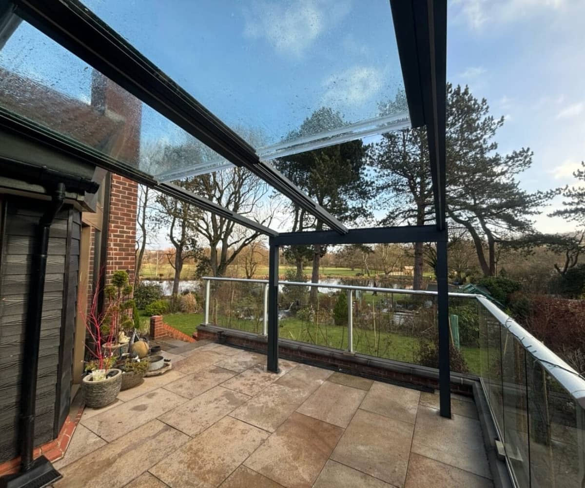 Glass veranda over a stone patio with garden views, showing a sheltered outdoor space for remote working.