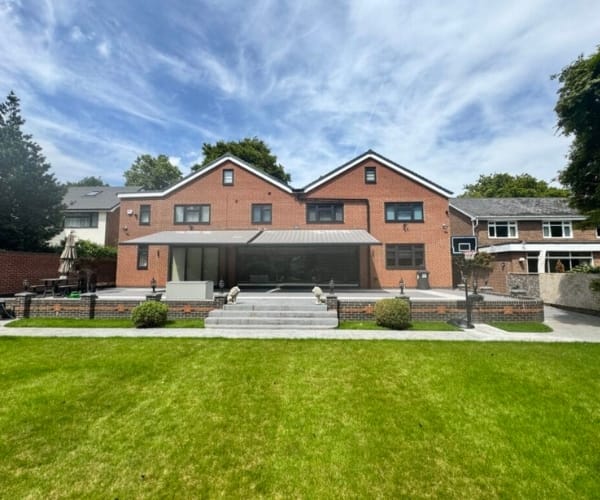 European-style garden awnings: Modern brick home with a landscaped garden and a minimalist awning providing shaded outdoor space