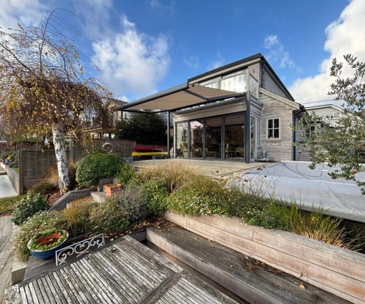 When to buy an awning: Modern home exterior with a large retractable awning fitted above patio doors, illustrating residential awning installation.