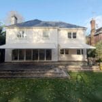 seasonal awnings inline image: Rear view of a large white house with two extended awnings providing shade over a patio and terrace area.