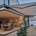 fade-resistant awning fabric: an image of an awning installed by the great british awning and blind company above a tasteful garden room